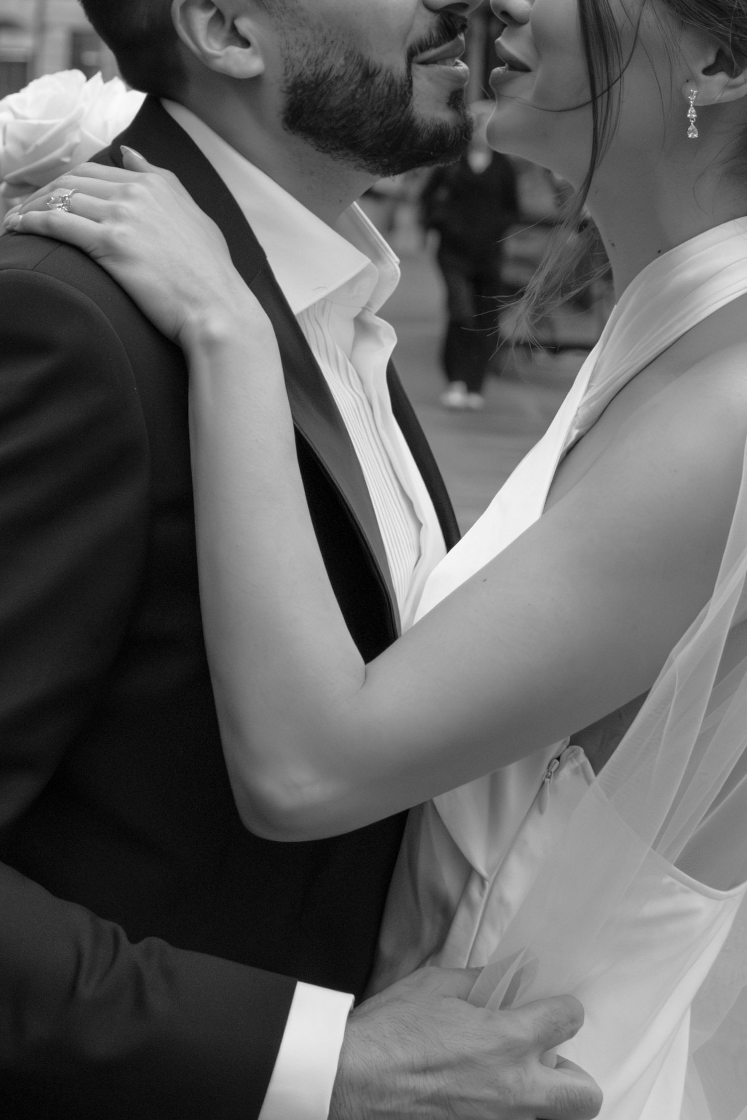 Black and white photo of a bride and groom sharing a romantic almost-kiss on their wedding day.