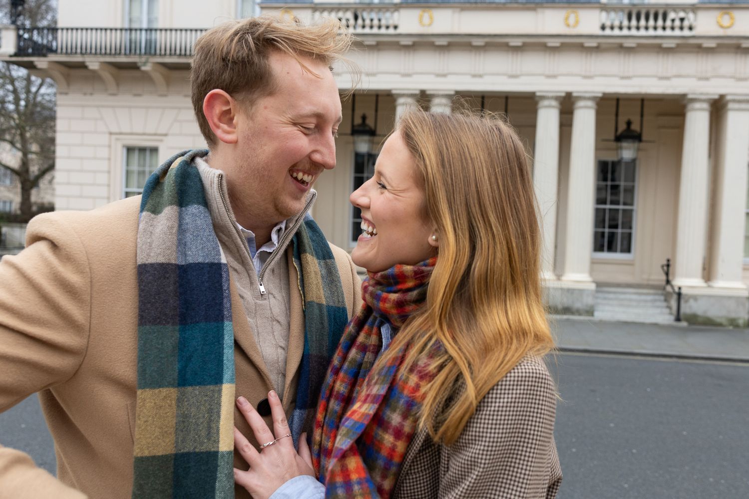 A romantic moment shared between two people outside a classical architectural building.