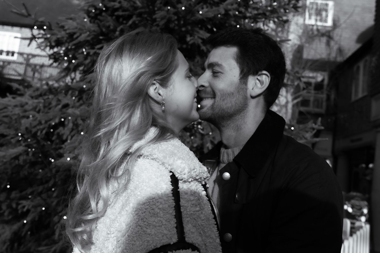 A romantic black and white photograph captured against an architectural backdrop.
