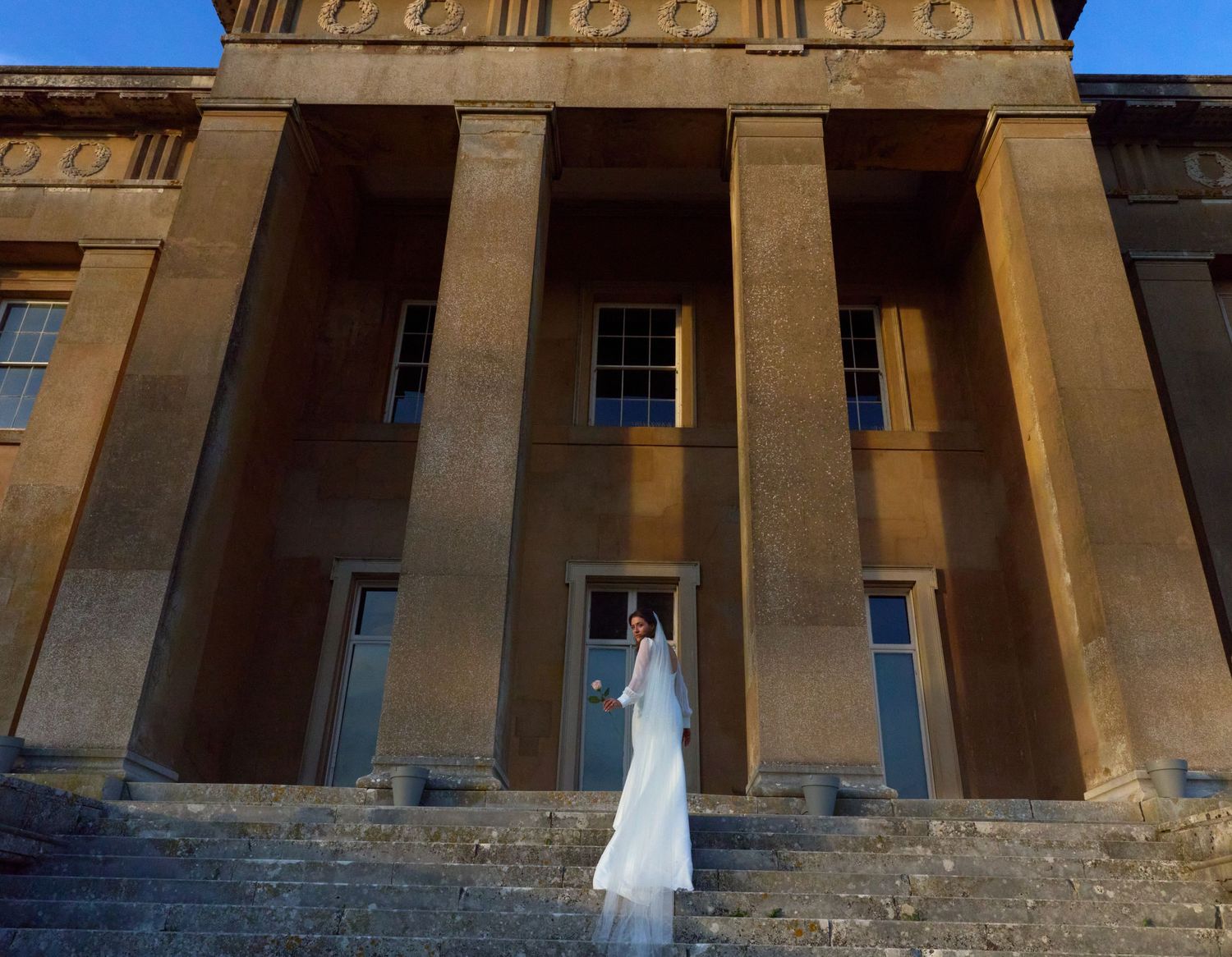Classical stone building exterior with dramatic columns and architectural details.