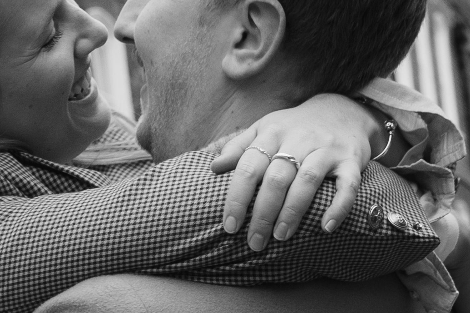 Close-up detail of hands and clothing during an intimate embrace.