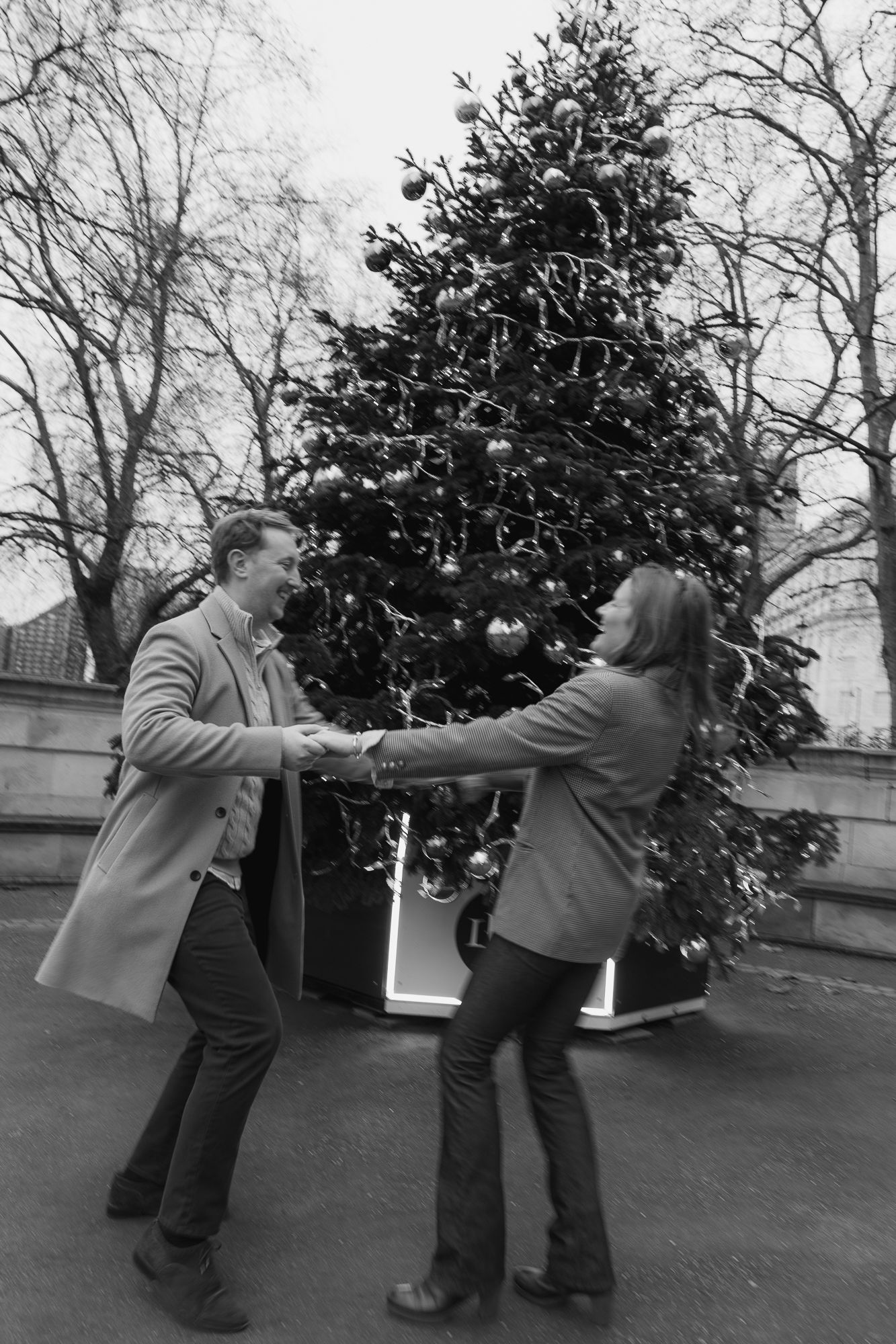 A playful moment captured in a series of photos showing two people dancing and spinning near a decorated Christmas tree.