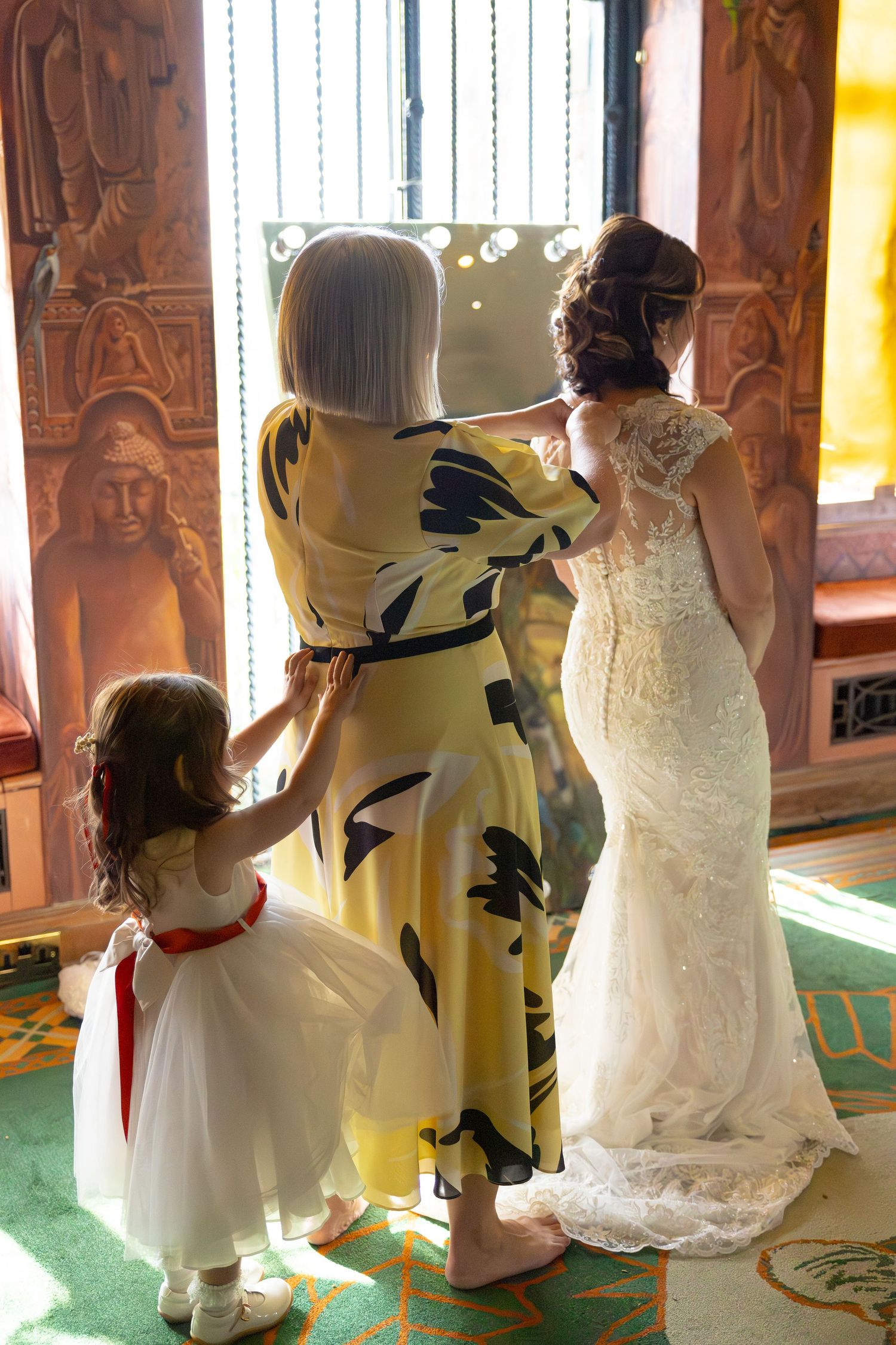 Wedding dress sequence showing the back details of a floral yellow and white dress next to a white bridal gown.