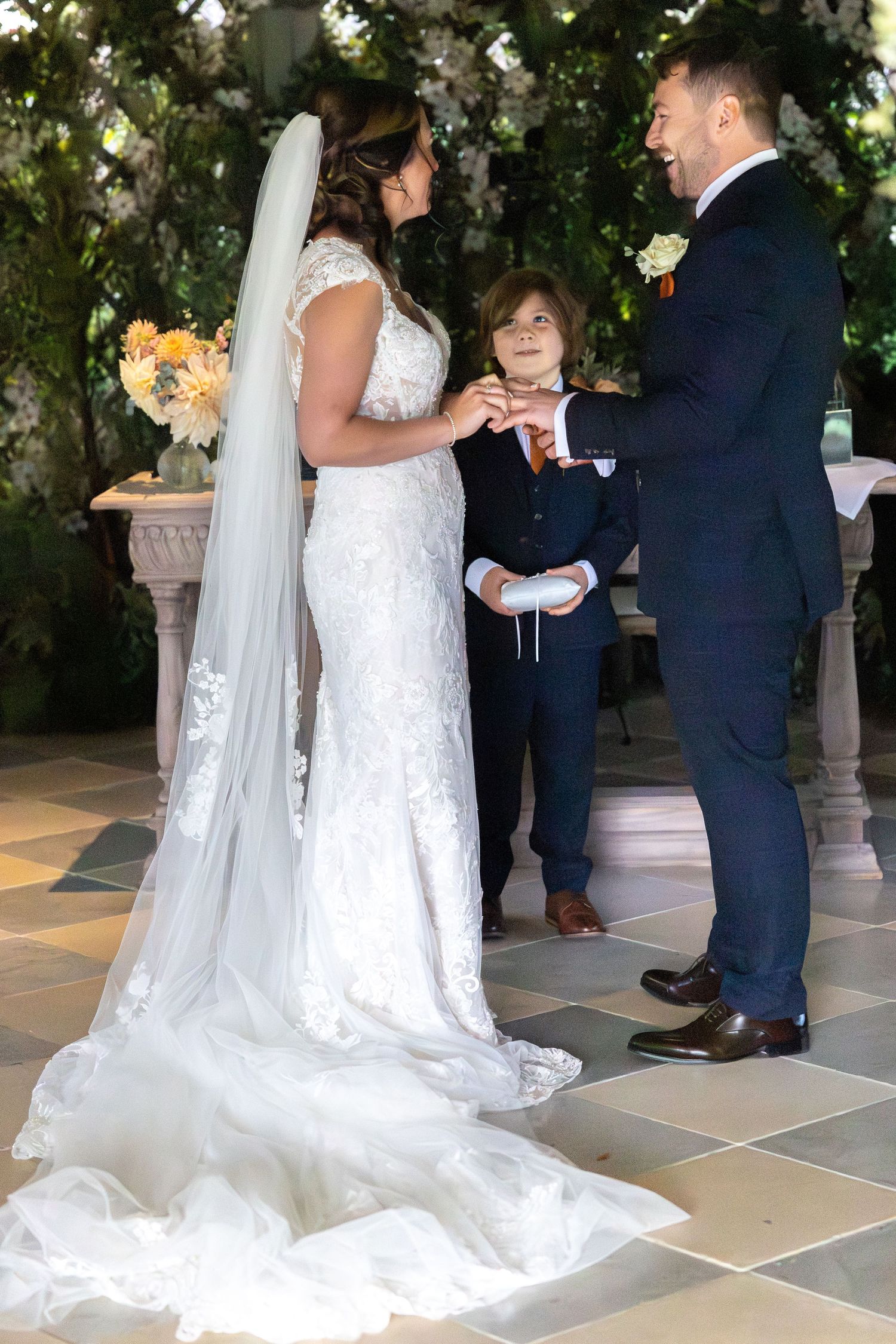 Wedding ceremony sequence showing couple exchanging vows under floral-decorated archway.