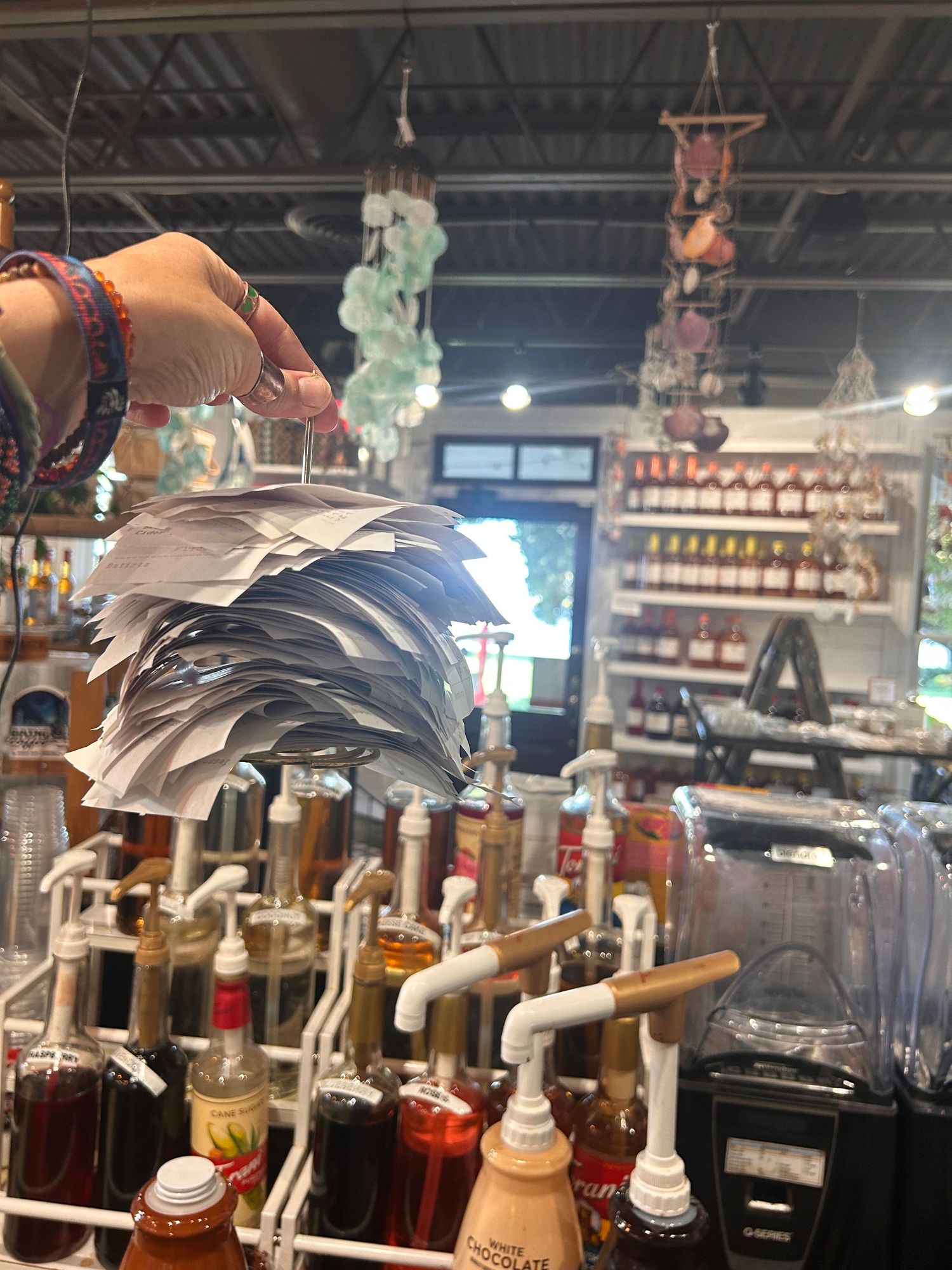 Bar setup with multiple beverage taps and decorative hanging elements in an industrial-style establishment interior.