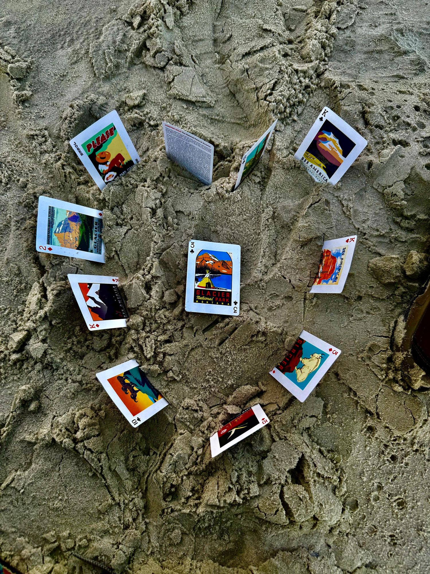 Multiple Polaroid-style photographs scattered on a sandy gray textured surface creating an artistic arrangement.