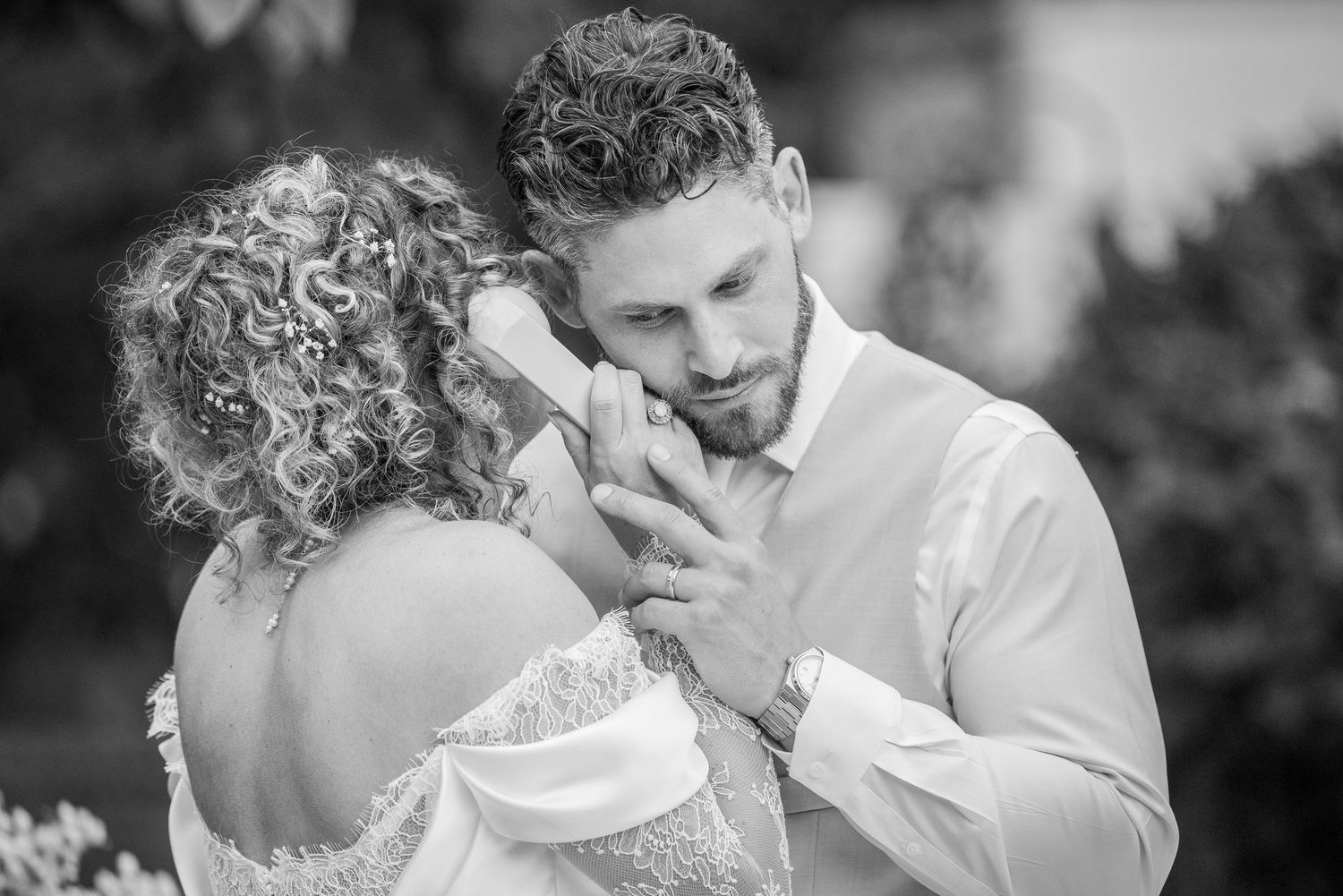 An intimate black and white portrait of a tender moment between newlyweds.
