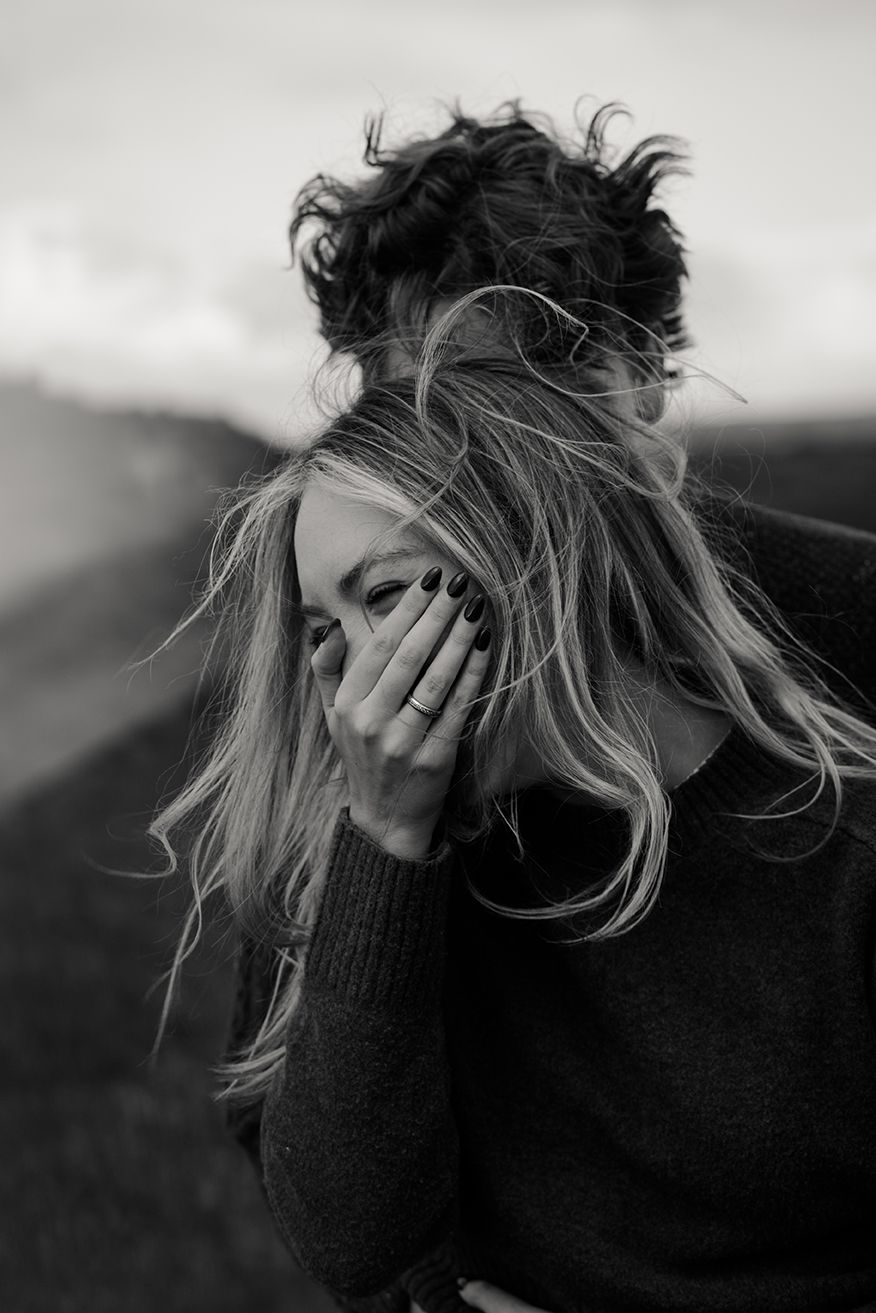 couple celebrating their engagement on their trip to Ireland by the cliffs of Moher with an epic, adventurous photo session