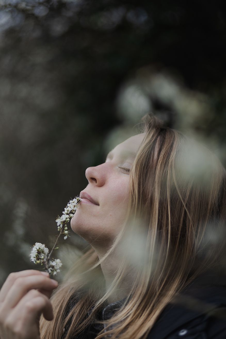 portrait of  a woman holding a blooming tree at spring in galway