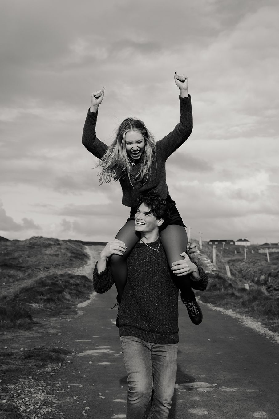 fun, adventurous couple celebrating their engagement on their trip to Ireland by the cliffs of Moher with an epic photo session