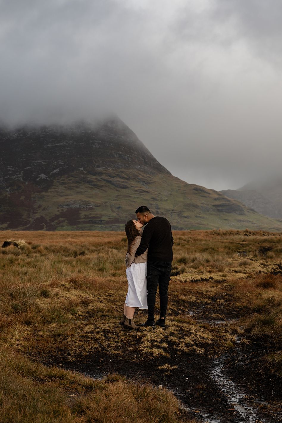 couple standing close to each other, kissing during their adventure photo session in beautiful Connemara national park