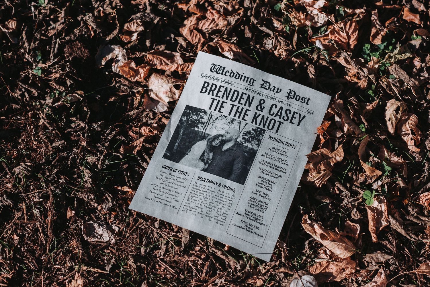 A newspaper lying on fallen autumn leaves with a dramatic headline visible in black and white.