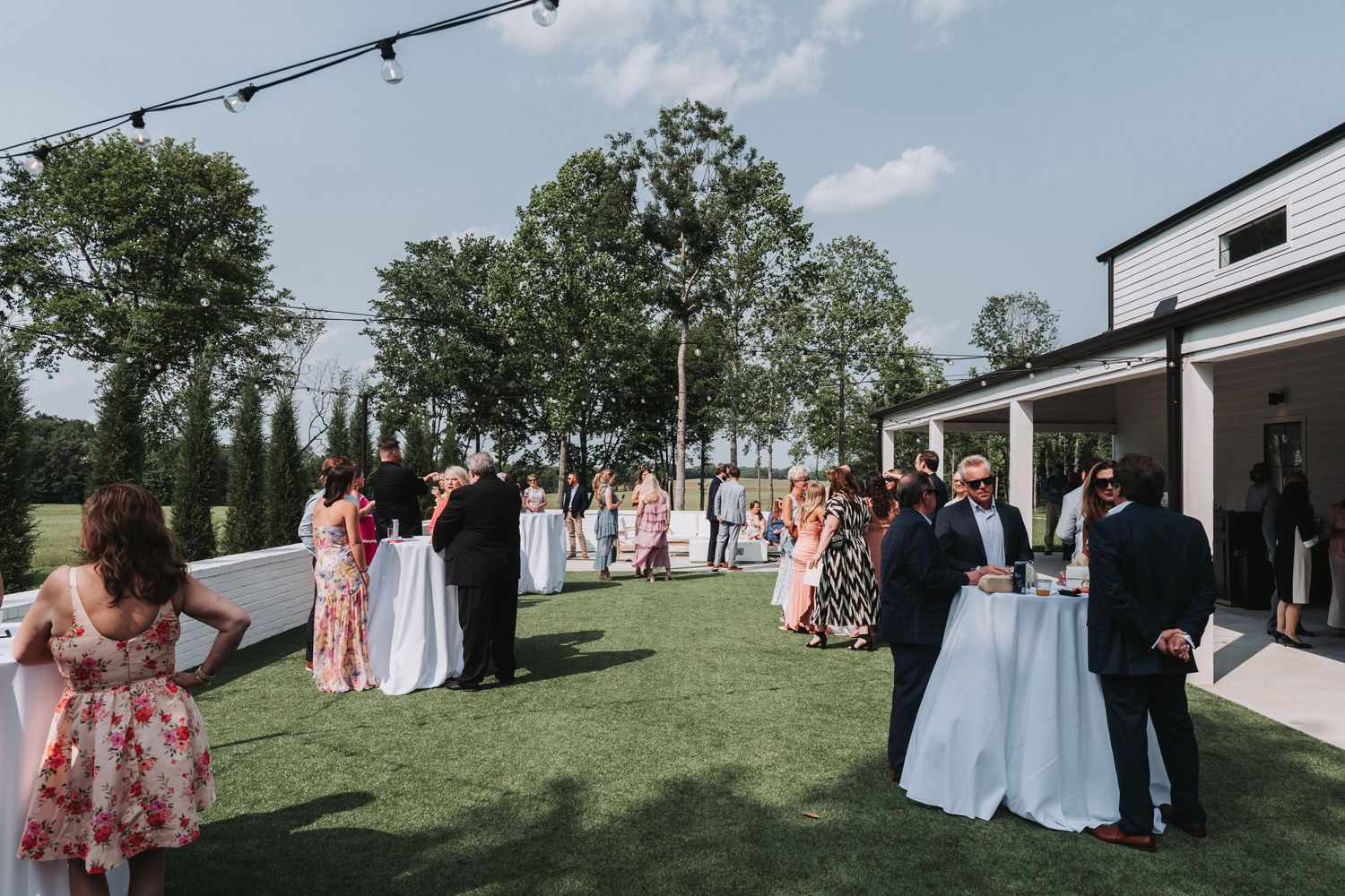A series of panoramic shots showing an outdoor wedding reception setup with white tables and chairs on a grassy lawn.