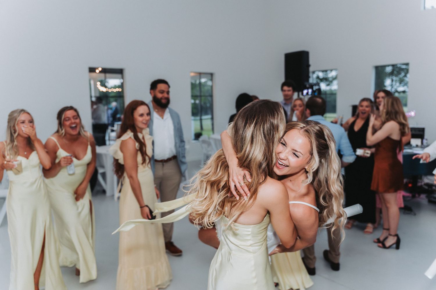Guests dance and celebrate together at a lively wedding reception in a bright indoor venue.