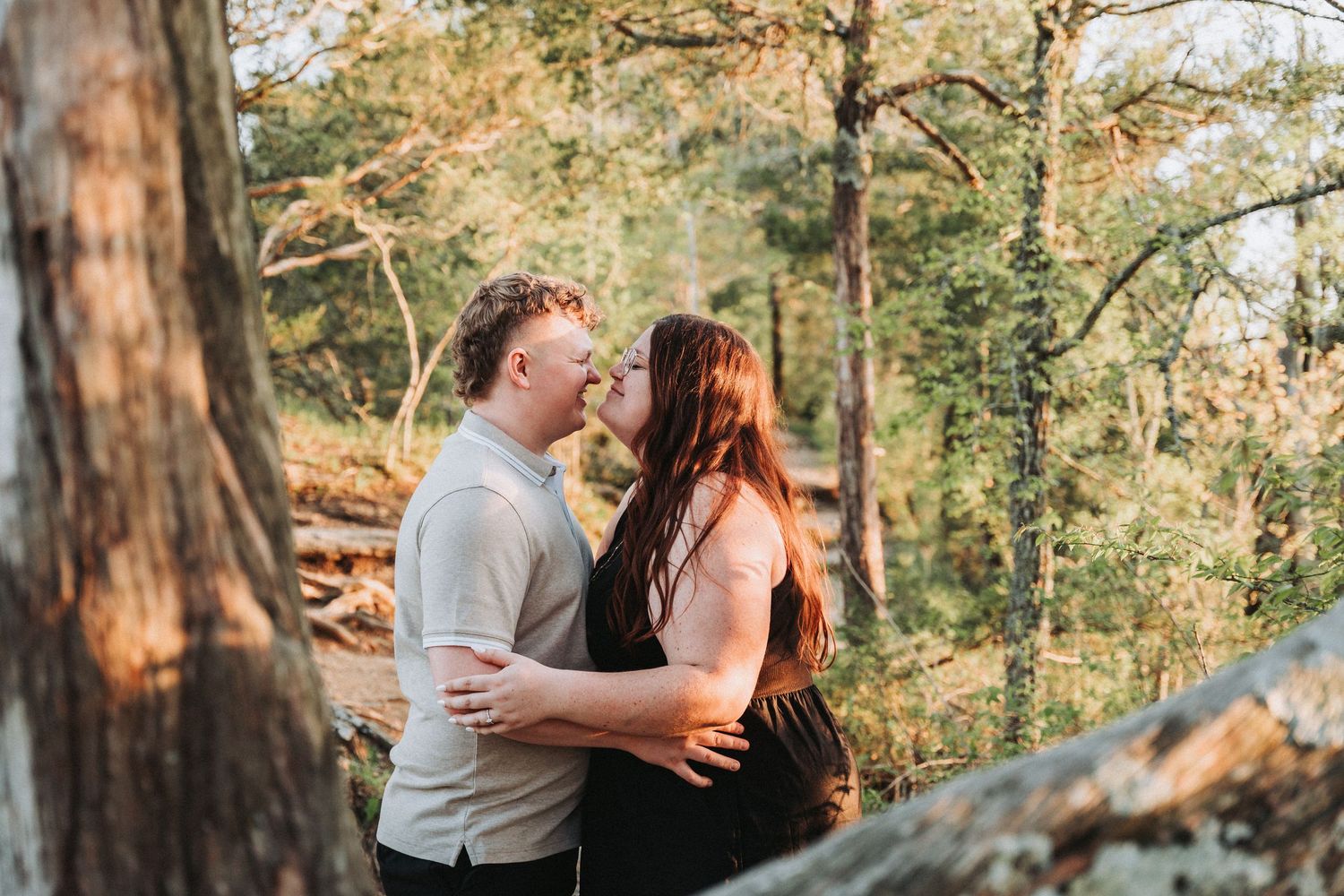 Couple embraces during sunset photoshoot in autumn forest setting.