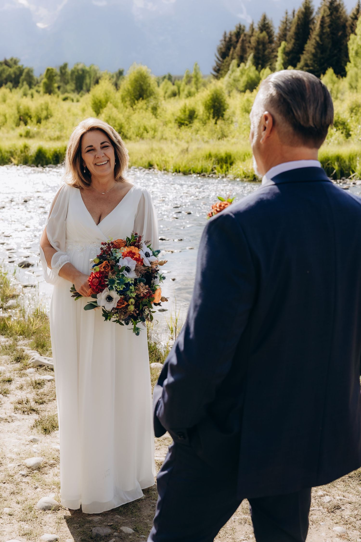 Outdoor mountain wedding ceremony with dramatic landscape backdrop.