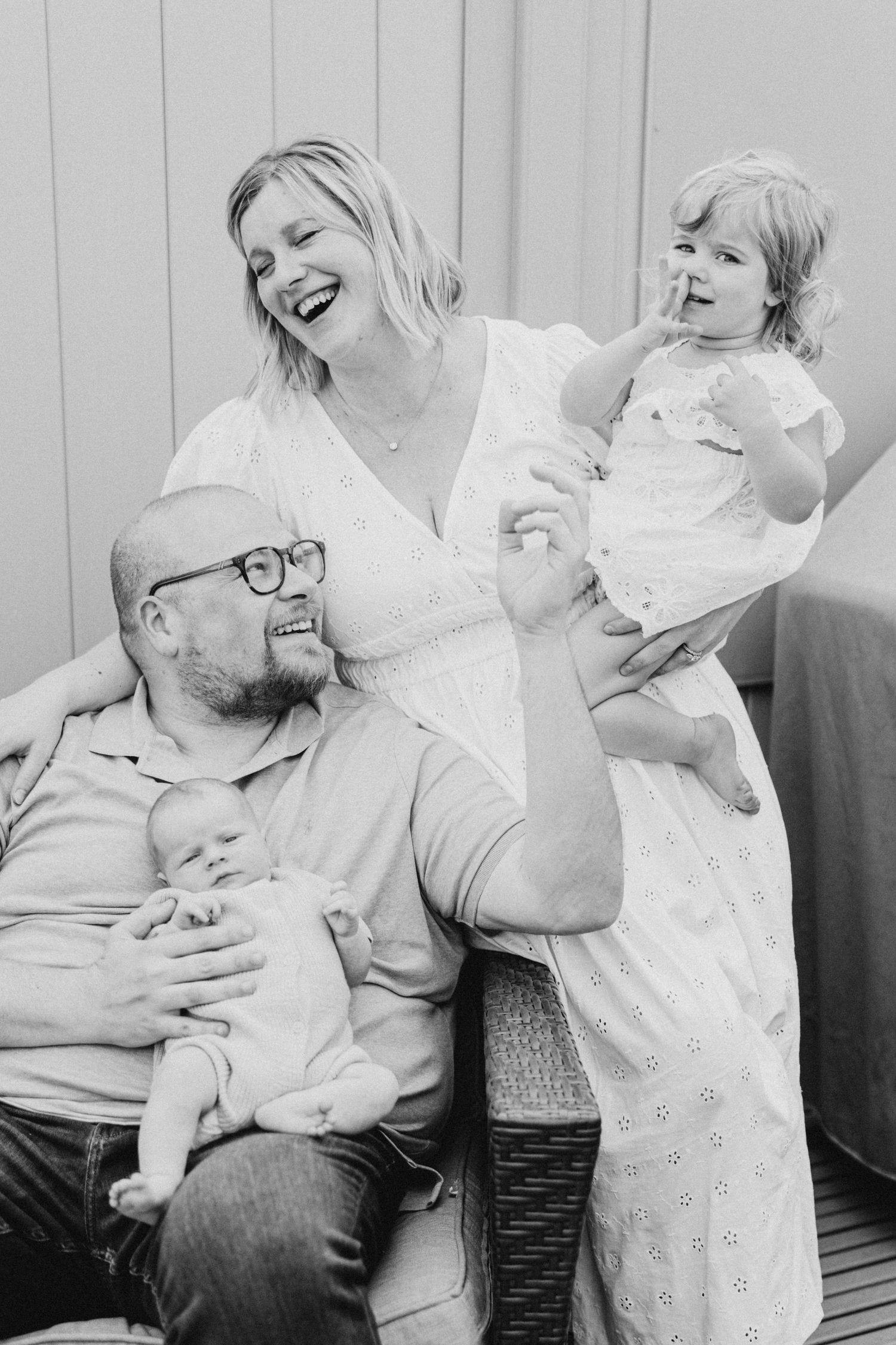 A candid black and white family portrait showing pure joy and laughter together.