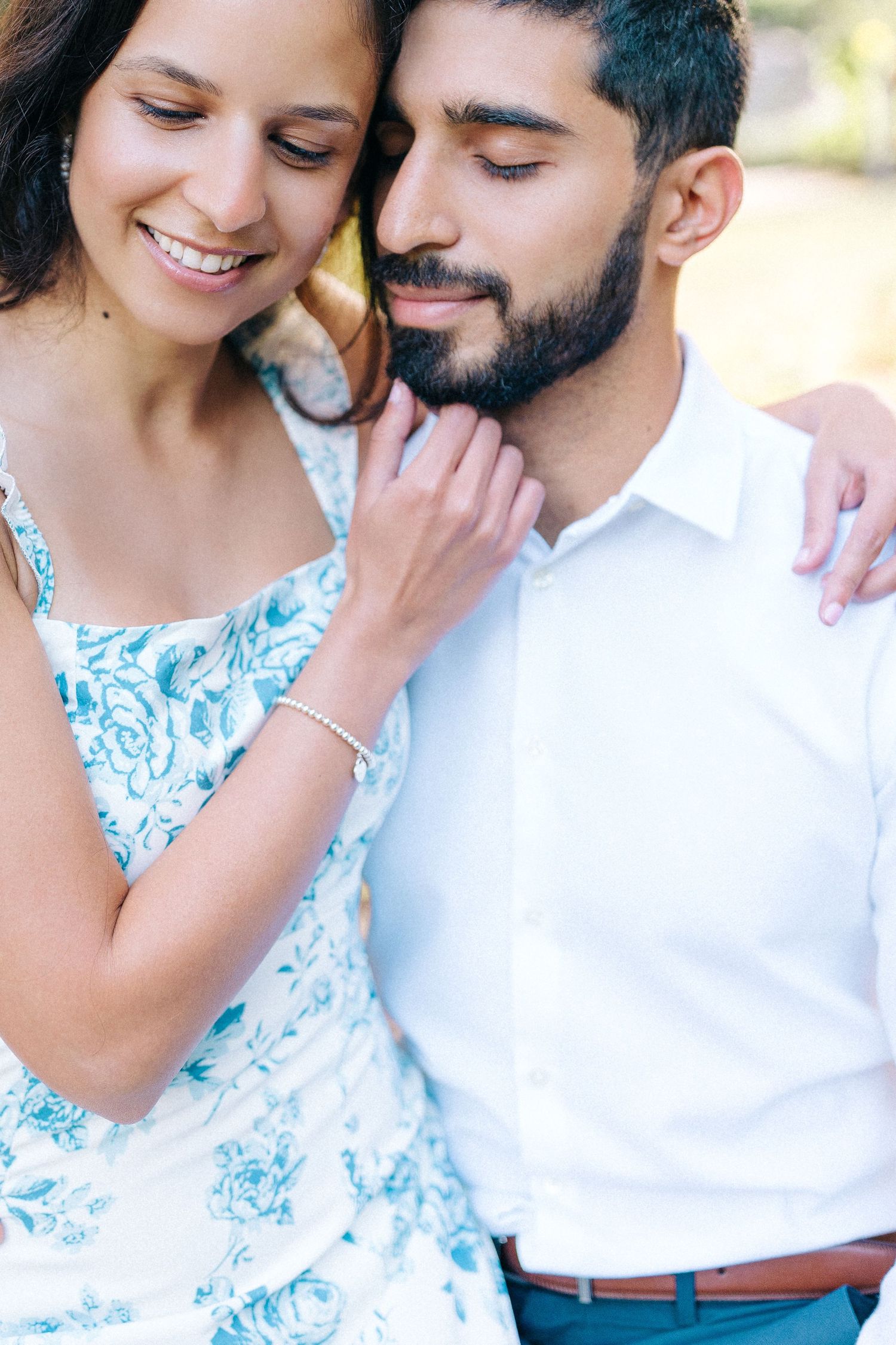 A couple in coordinated outfits share an intimate moment outdoors.