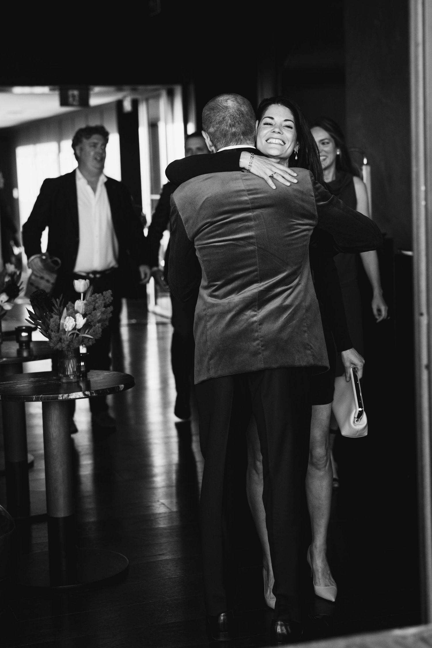 Emotional embrace captured in black and white at formal event.