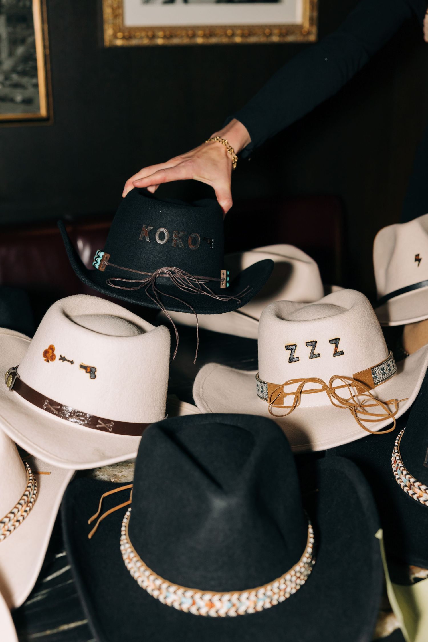 Collection of white and black cowboy hats with decorative bands displayed together.