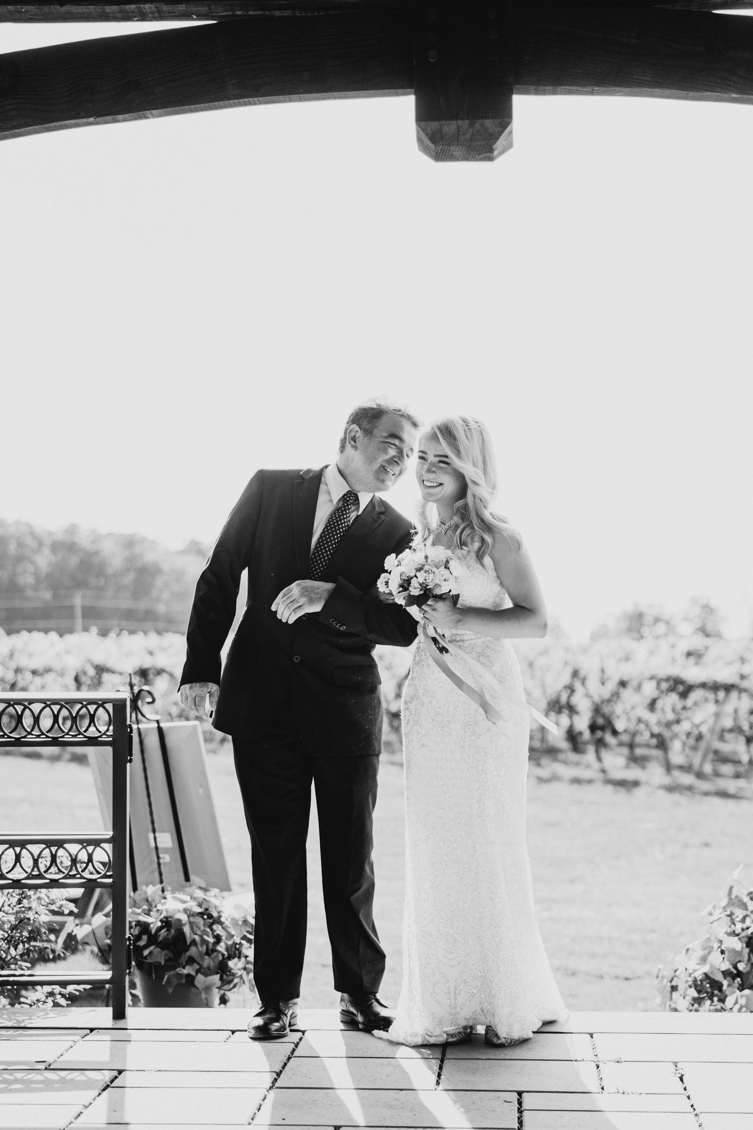 Wedding couple sharing a moment under a gazebo overlooking a scenic landscape.