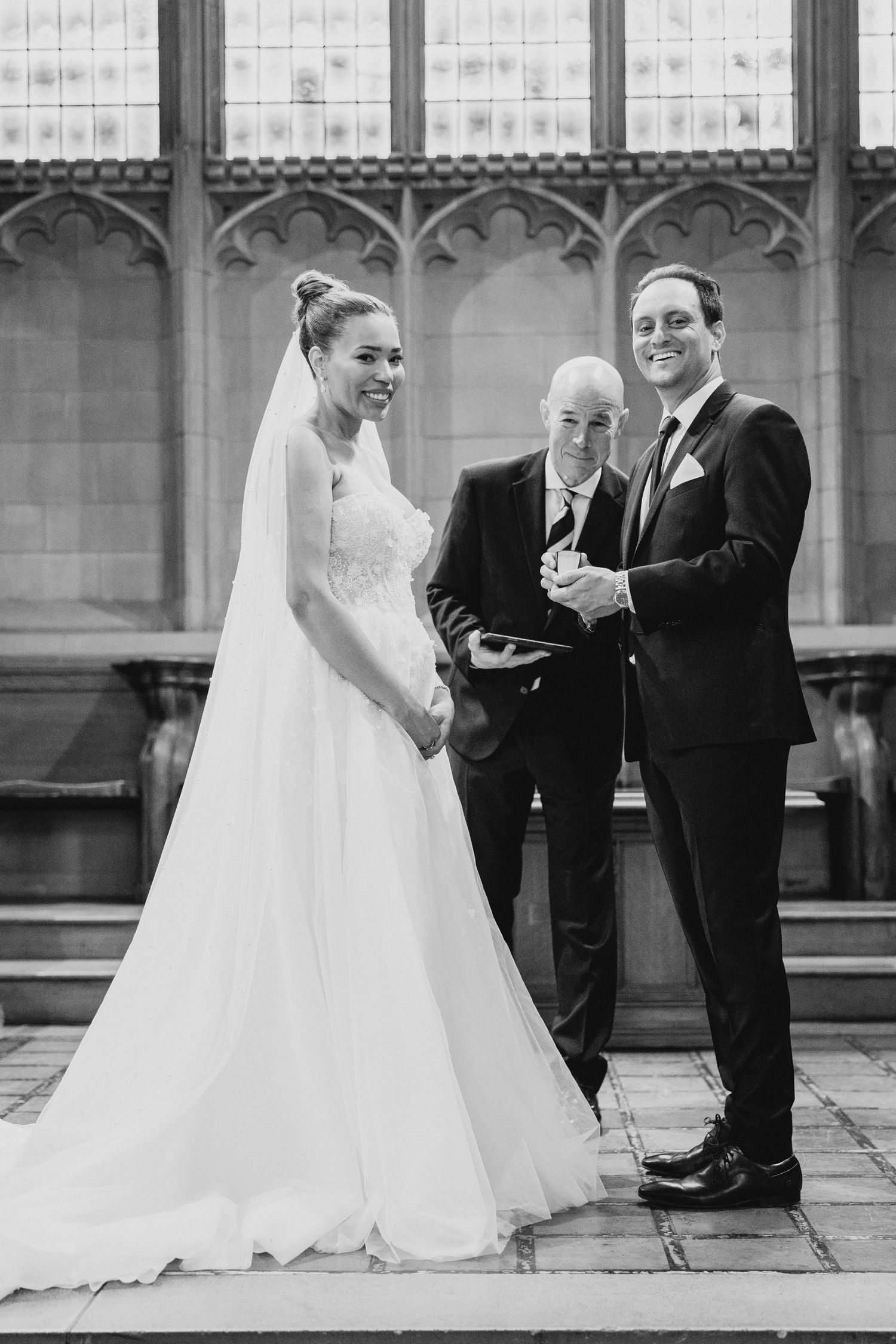 Wedding ceremony in gothic cathedral setting with couple and officiant.