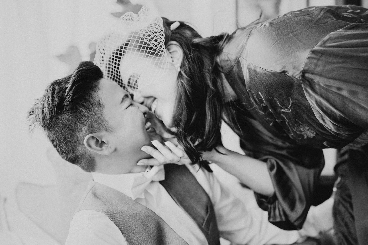 Black and white romantic photograph showing an intimate moment between a couple in vintage style.