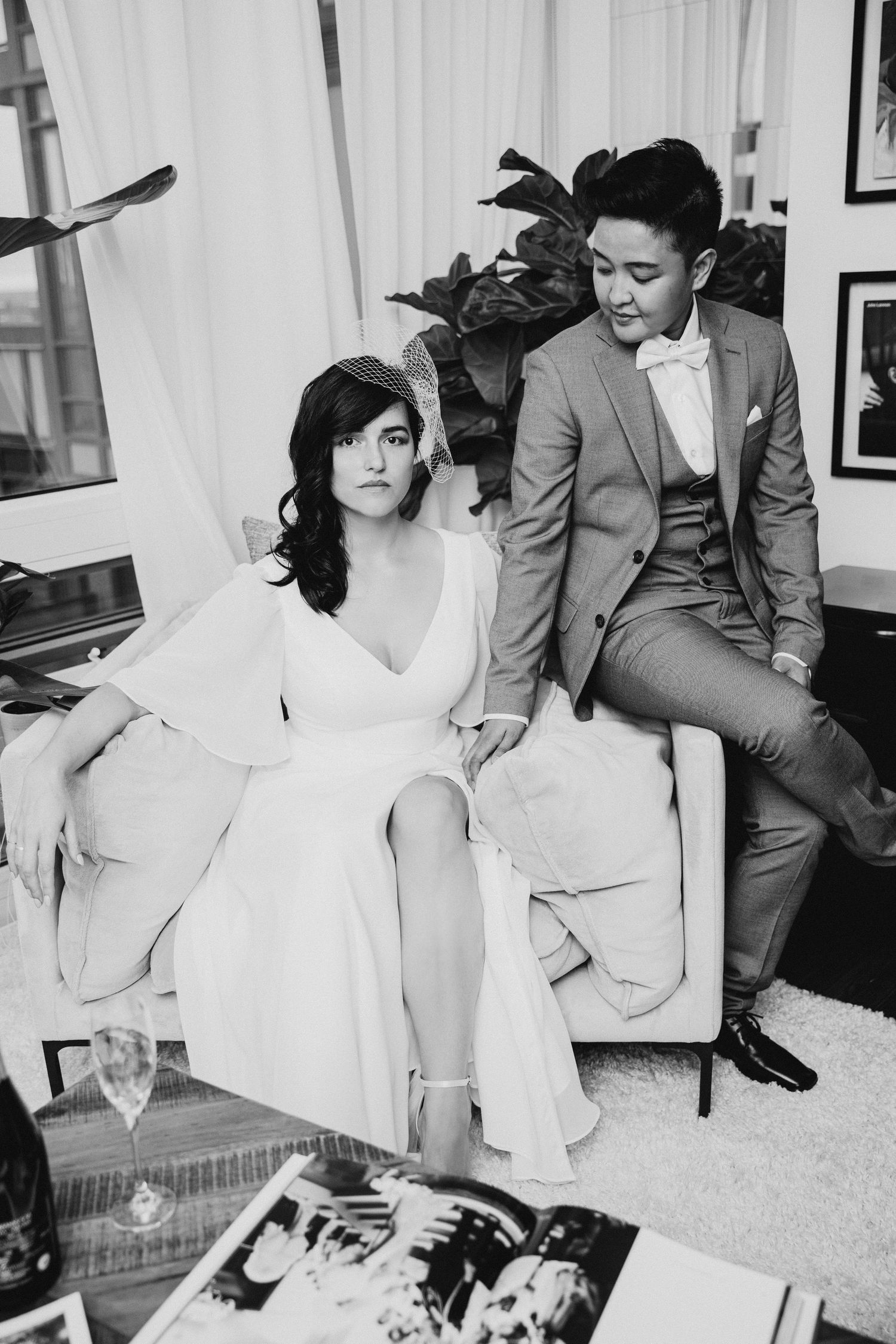A romantic black and white photo of a couple at home, with one person in white and another in a gray suit.