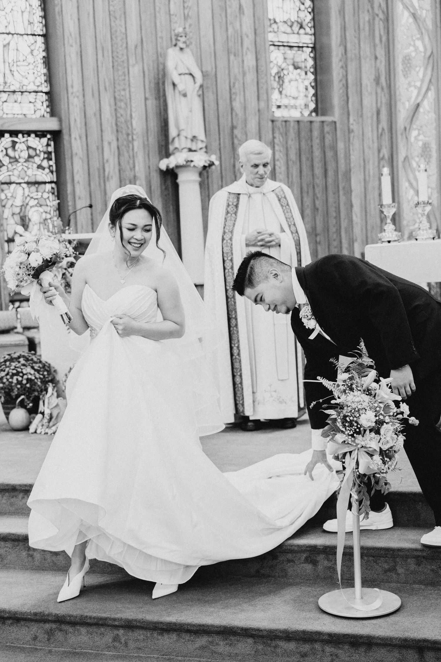 Black and white photo of a cheerful moment during a church wedding ceremony.