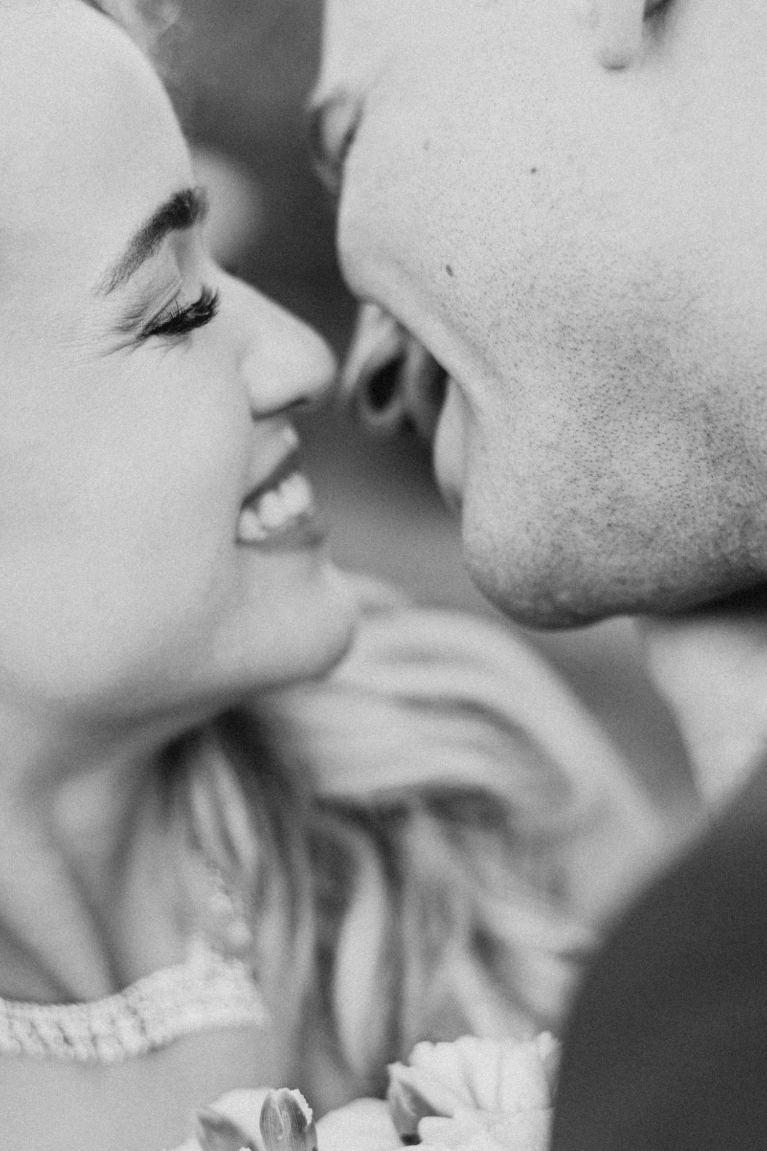 Black and white intimate close-up of couple sharing a romantic moment.