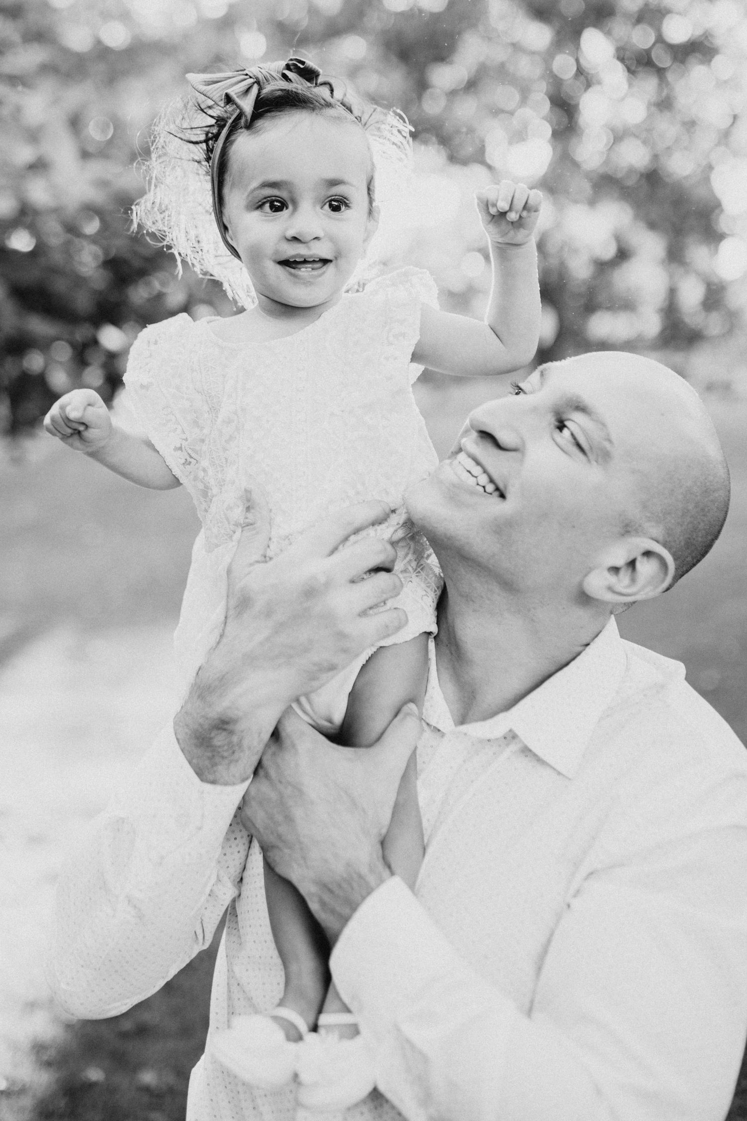 A heartwarming outdoor portrait capturing a playful moment in black and white.