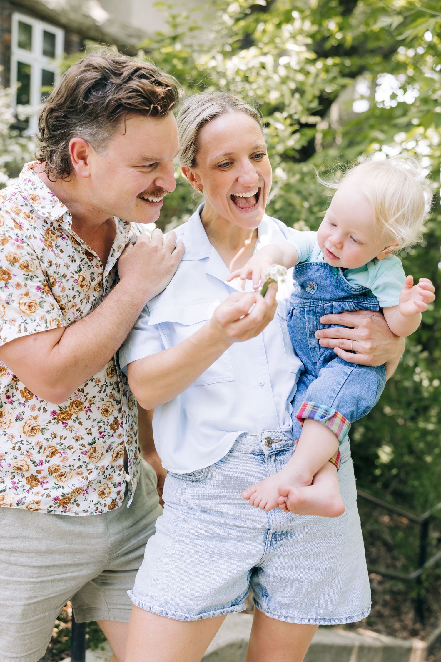 A family shares a joyful moment together outdoors on a sunny day.