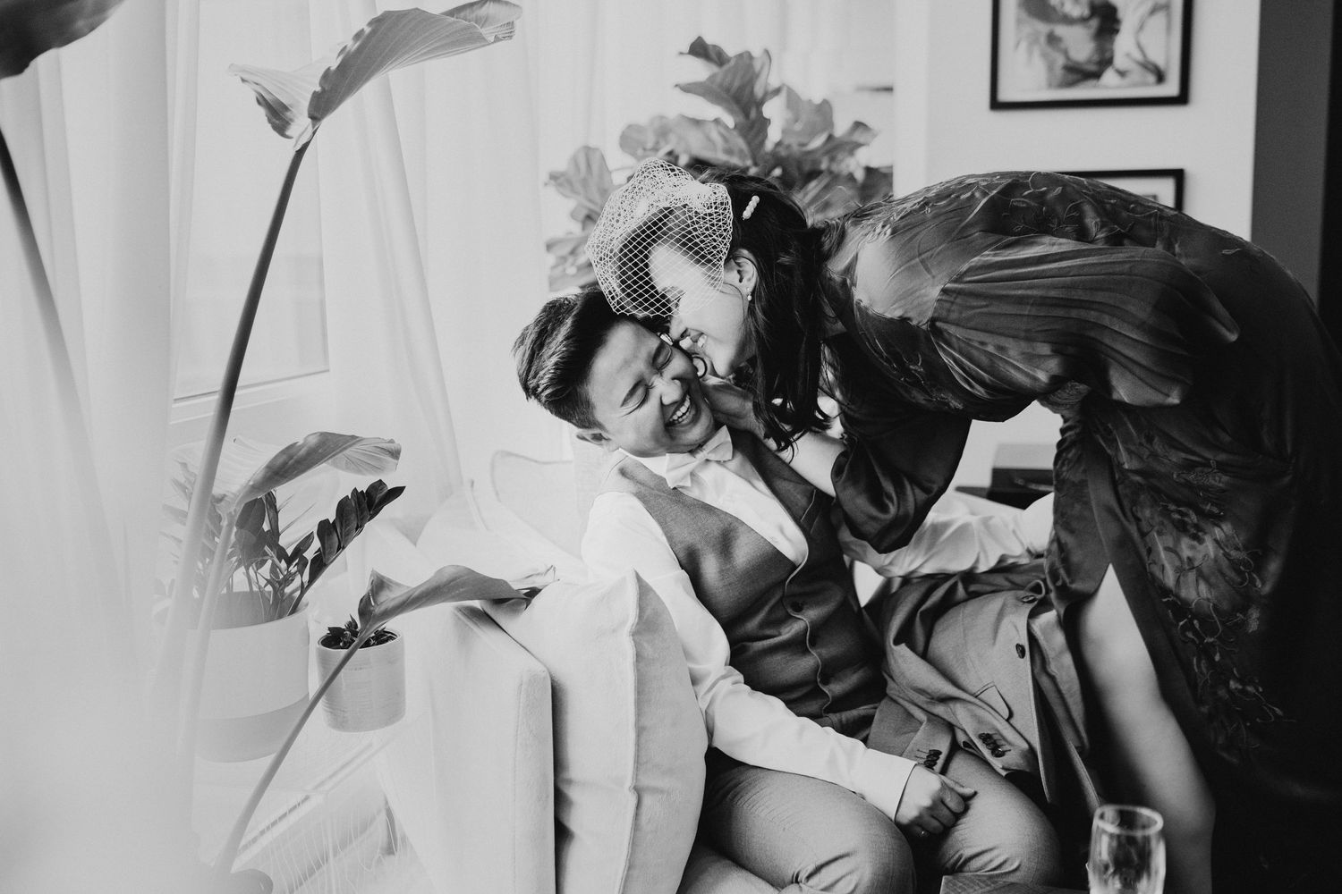 A black and white vintage photograph of a romantic scene between two figures lounging on a couch.