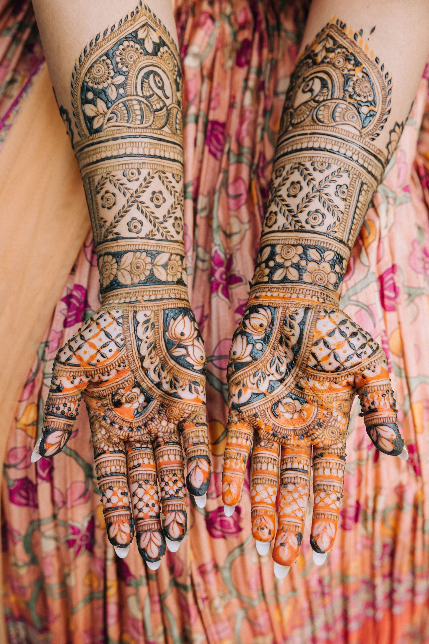 Intricate henna mehndi designs adorning both hands with detailed geometric patterns and traditional Indian bridal artwork.