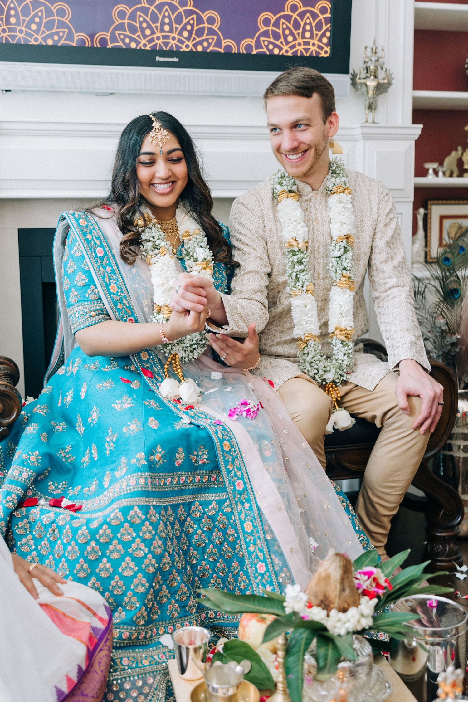 Couple in traditional Indian wedding attire sharing a moment during ceremony.