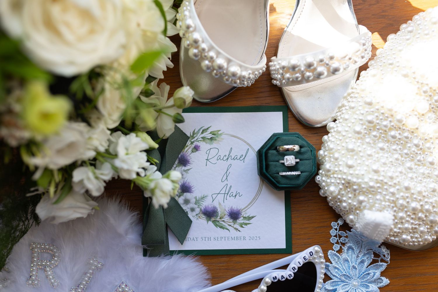 Collection of romantic wedding details including place cards, floral arrangements, and delicate lace decorations on a white surface.