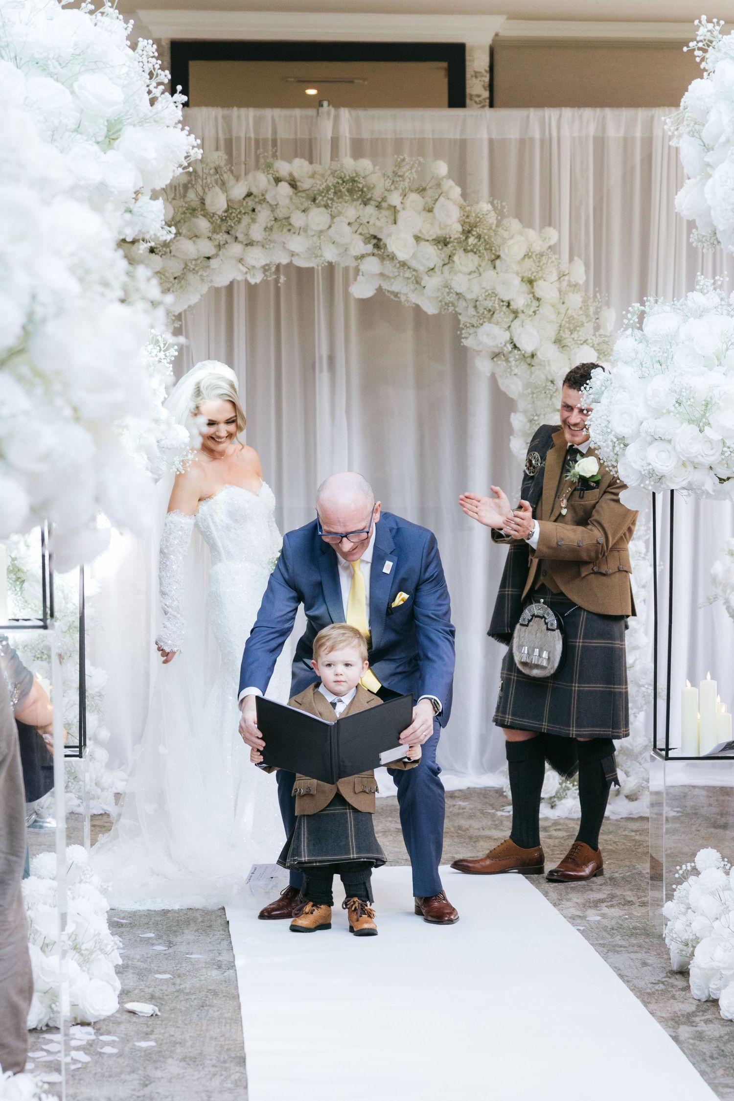 Multiple shots of a wedding ceremony setup with white floral arrangements and guests preparing for the event.