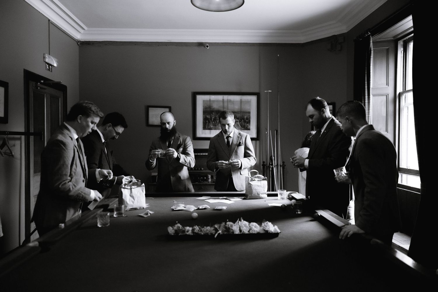 A series of black and white photos showing a dimly lit interior room with figures in silhouette near windows.
