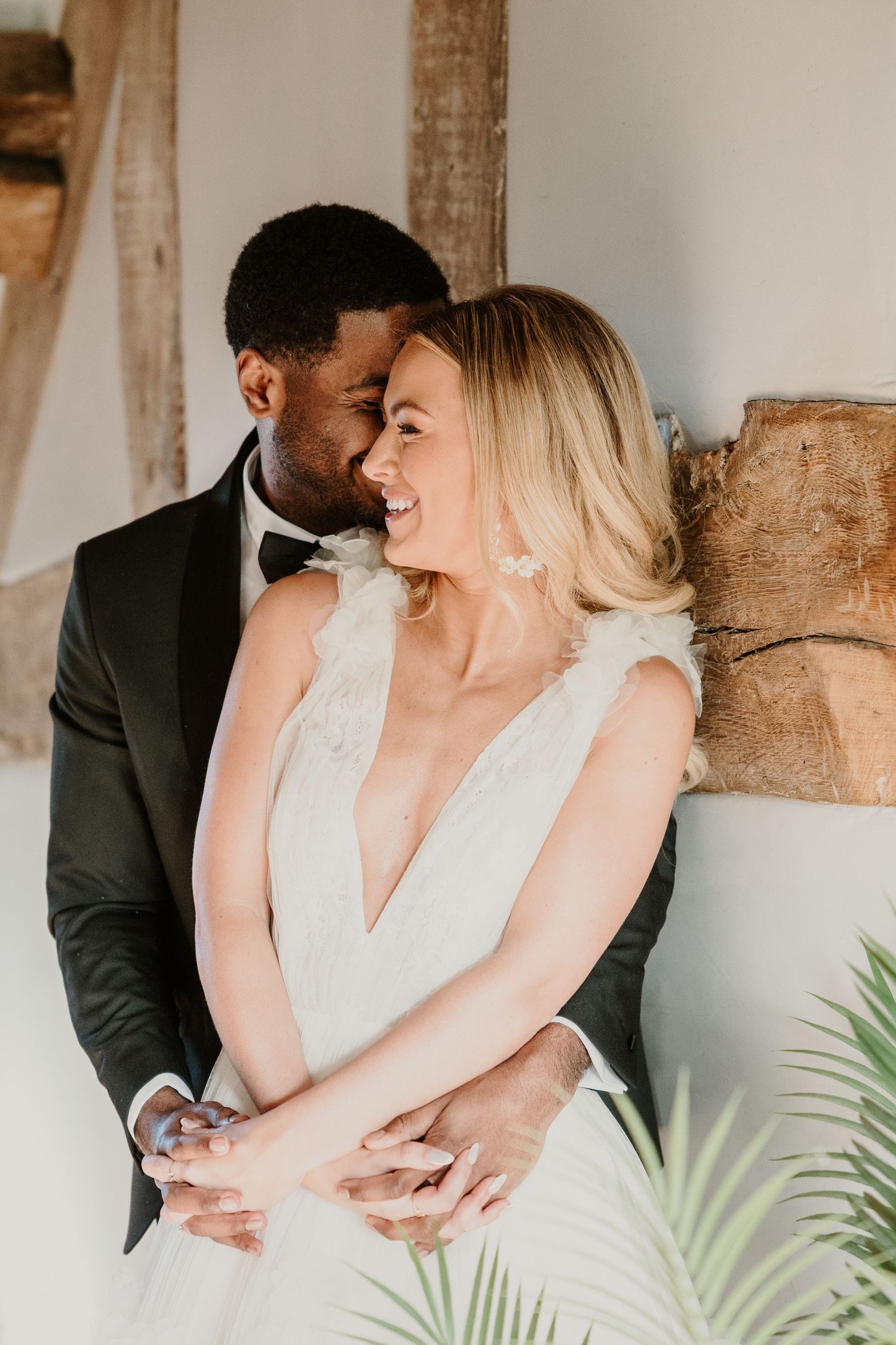 Candid indoor wedding portrait of a couple sharing an intimate moment.