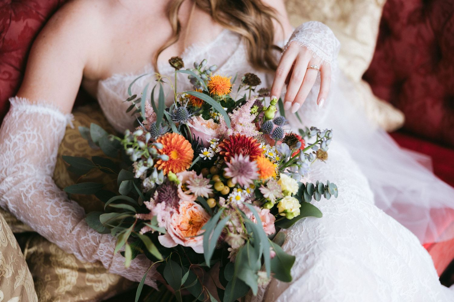 A romantic bridal bouquet featuring peach and coral flowers with eucalyptus greenery against a soft blurred background.