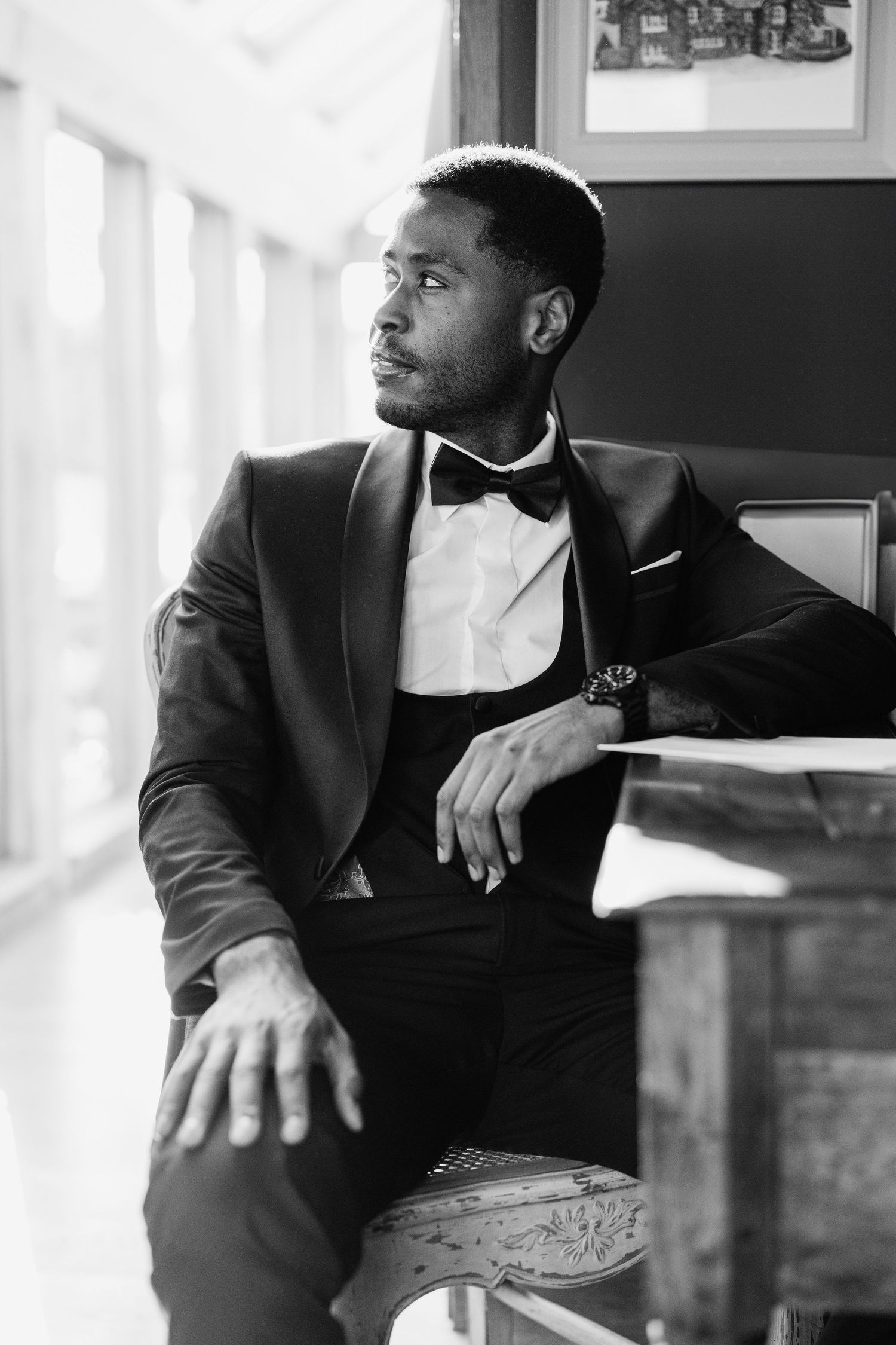 Three atmospheric black and white portraits of a man in a suit gazing contemplatively out a window.