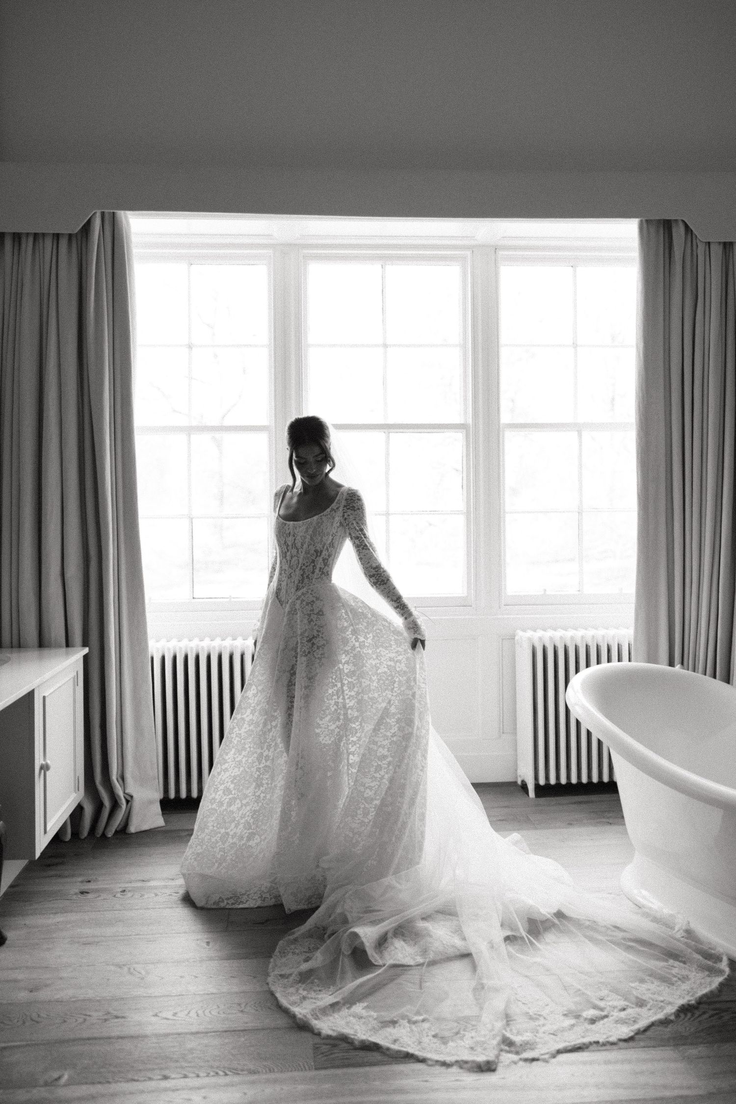 A series of artistic black and white photos showing the flowing train of a wedding dress in natural window light.