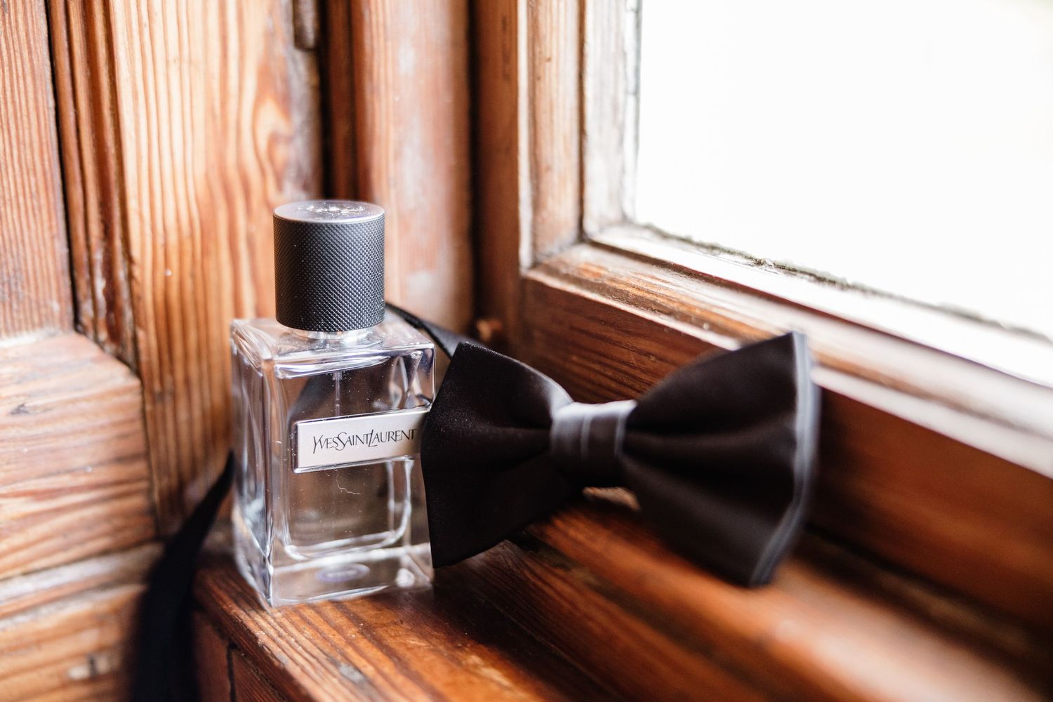 A rustic wooden window frame with a small glass of water sitting on the sill in warm natural lighting.