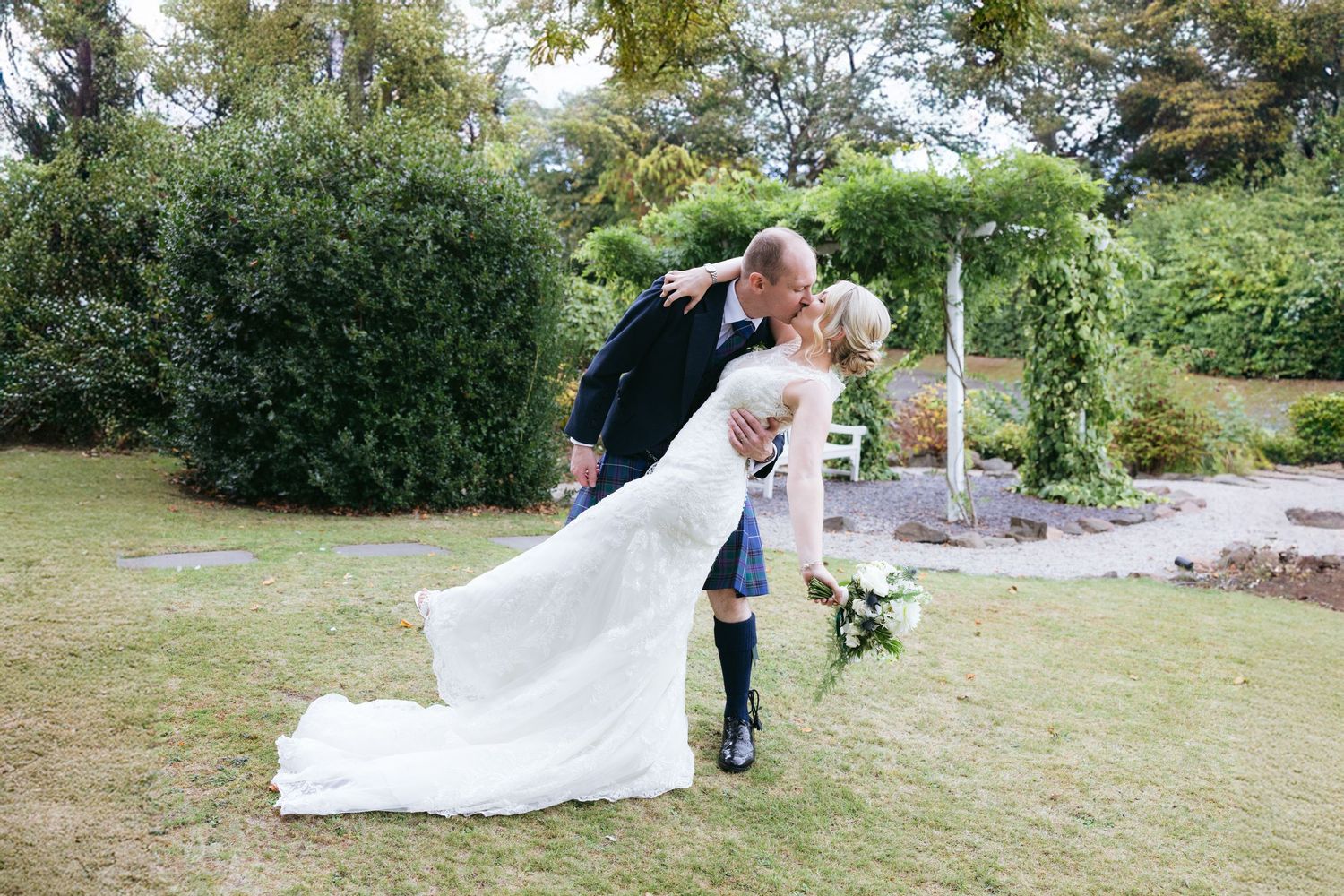 A romantic outdoor garden wedding photo of a couple sharing an intimate moment on their special day.