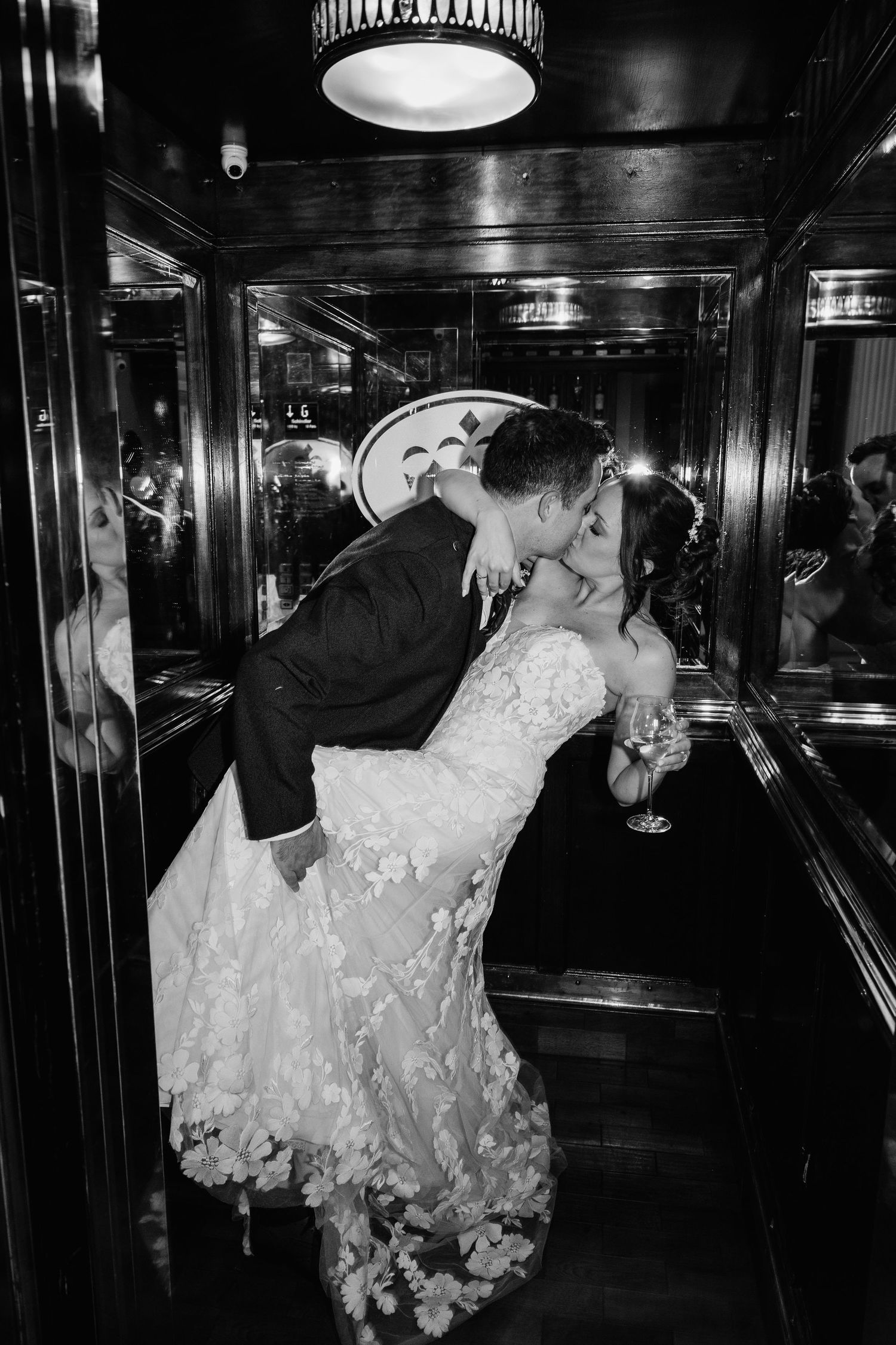 A couple shares their first dance in a dimly lit ballroom during their wedding reception.