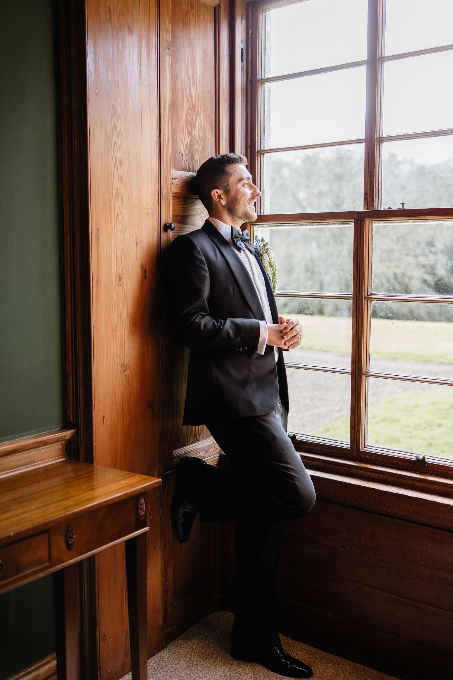 A series of photos capturing someone in formal attire gazing thoughtfully through a sunlit window in a wooden room.