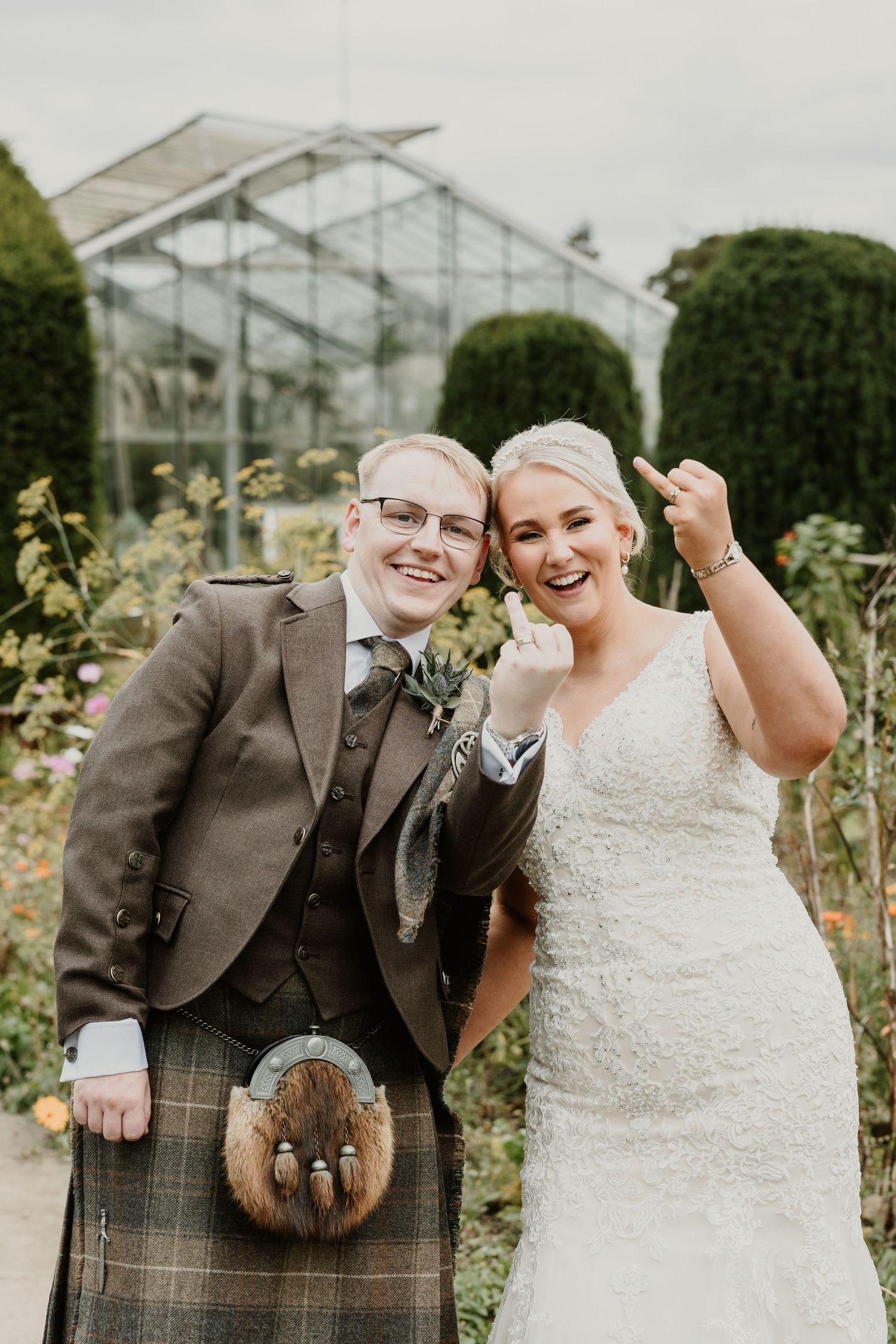 Couple in wedding attire poses in front of greenhouse with brown rabbit in multiple candid shots.