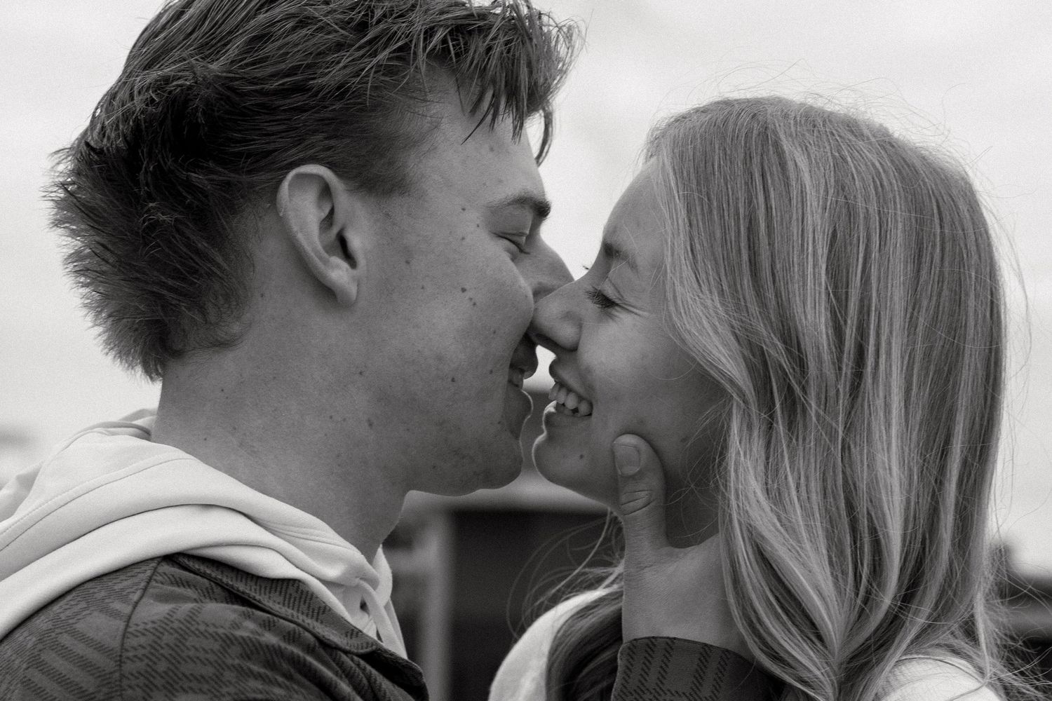 A tender black and white romantic moment captured between two people sharing a smile while about to kiss.