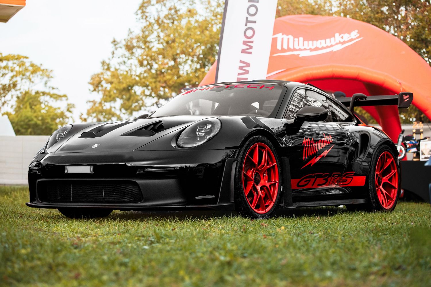 Détail du profil d’une voiture Porsche noire et rouge, avec le logo ShiftTech visible.