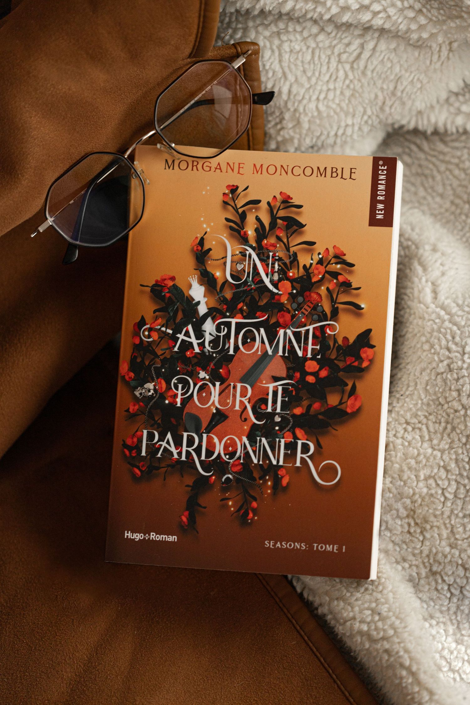Livre de Morgane Moncomble, un automne pour te pardonner, avec des lunette fond en accord la couverture du livre